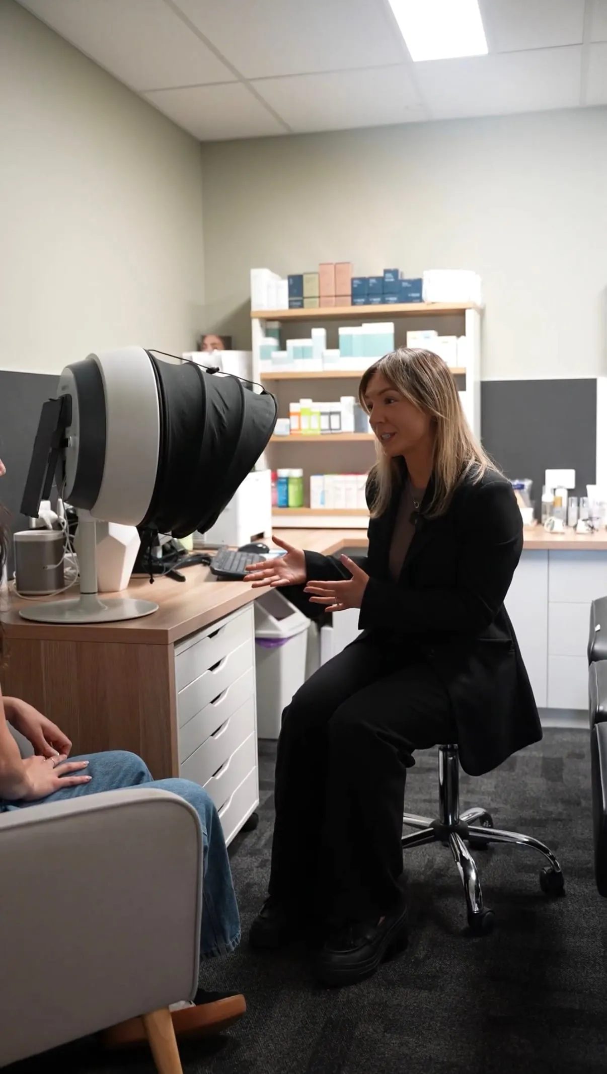 An aesthetic clinician talking a patient through a personalised treatment plan during a skin consultation