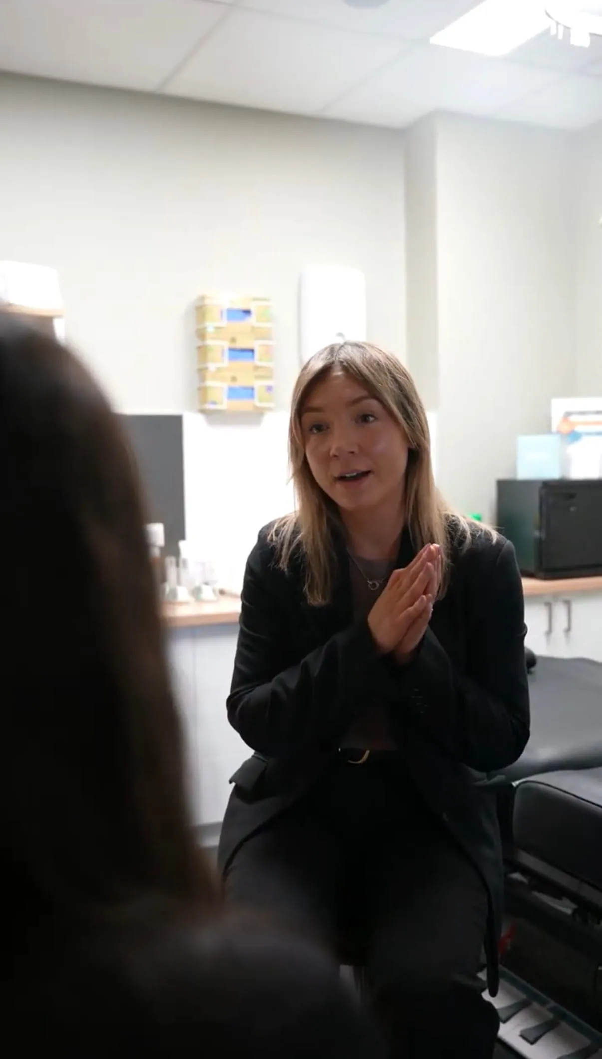 A clinician in conversation with a patient in an aesthetics treatment room at The Skin Doctor