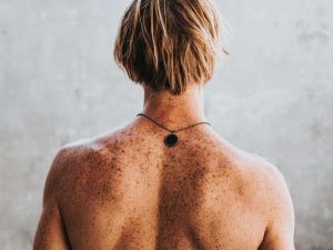 A man with freckles on the back needs regular skin cancer checks for spotting signs of sun damage before it becomes skin cancer